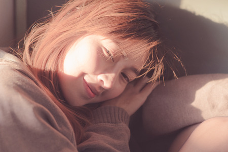 Young woman sitting in the sunの写真素材