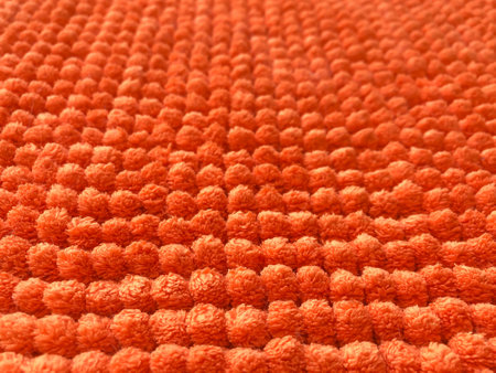 Orange doormat surface, has a round button of cloth, bright colors, close up, can use be background or wall paper, select focus pointの写真素材