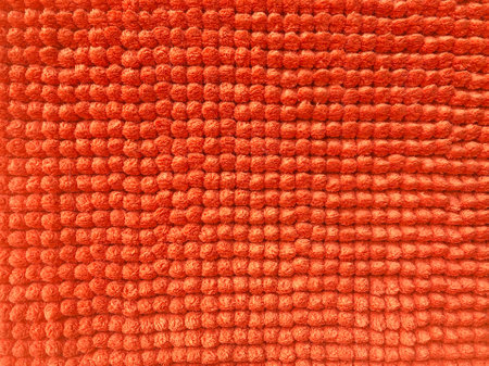 Orange doormat surface, has a round button of cloth, bright colors, close up, can use be background or wall paper, select focus pointの写真素材