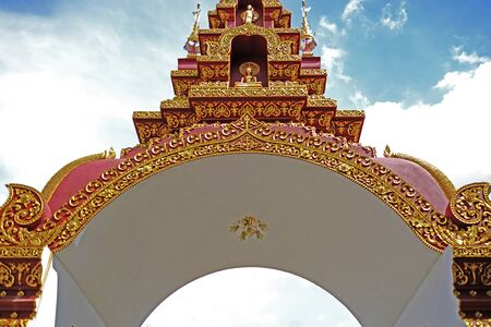 a traditional northern thai style (lanna) gate (an entrance) to a templeの写真素材