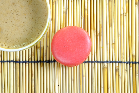 a colorful macaroon and a cup of coffee on a traditional japanese style reeds matの写真素材