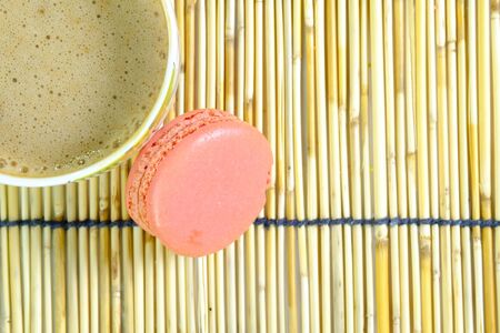 a colorful macaroon and a cup of coffee on a traditional japanese style reeds mattの写真素材