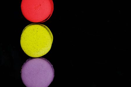 assortment of macaroons in various colors on black backgroundの写真素材