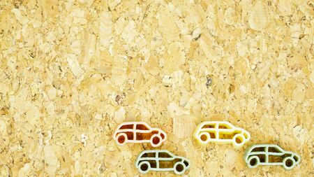 car shape pasta arranged in pattern on a cork boardの写真素材
