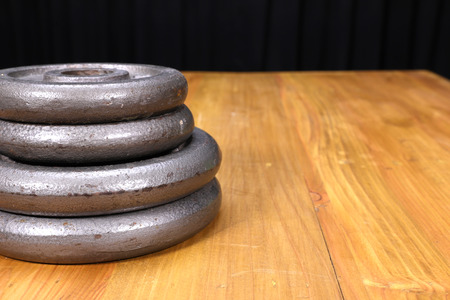 a stack of weight plates on a wooden table