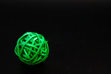 a ball of green rattan for decoration on black background