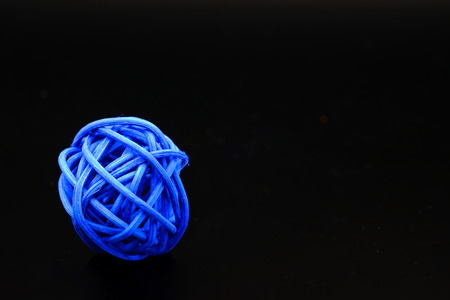 a ball of blue rattan on black bachjgroundの写真素材
