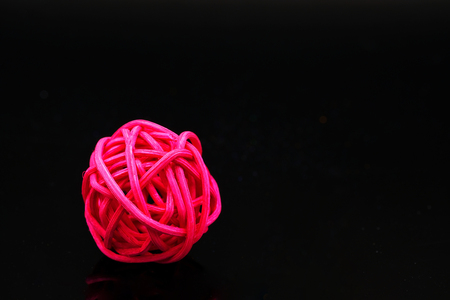 a ball of red colored rattan for decoration on black backgroundの写真素材