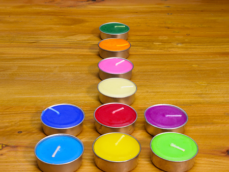 colorful fragrant wax candles arranged in geometric shape, shown on natural wood backgroundの写真素材