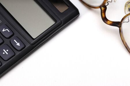 a calculator and a pair of glasses isolated on white backgroundの写真素材