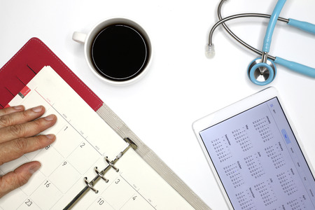 a doctor checking his appointment book, top view imageの写真素材