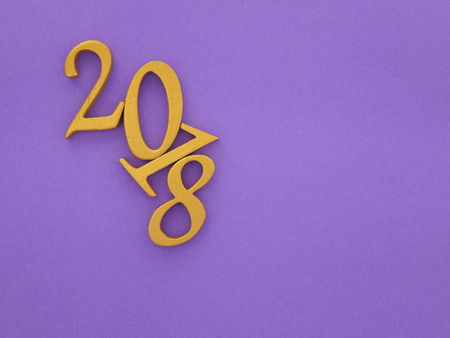 a golden new year 2018 banner on bright purple paper background