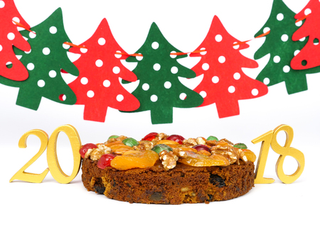 traditional fruitcake with fruits and nuts for the holidays, isolated on white backgroundの写真素材