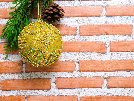 Gold Christmas ball on bricks and mortar backgroundの写真素材