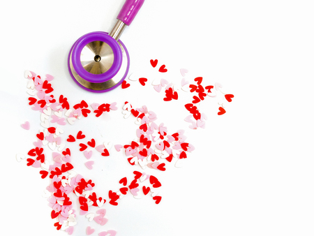a stethoscope and red, white, and pink heart-shaped pieces of plastic confetti, abstract love and compassion, Valentines' Day, romance,  concept, on white backgroundの写真素材