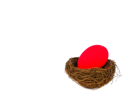 red easter egg in a bird nest, isolated on white backgoundの写真素材