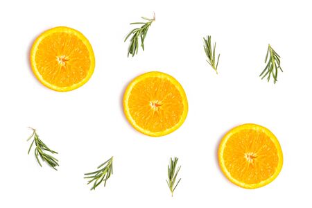 Colorful pattern of fresh summer orange slices with rosemary sprigs on whiteの写真素材