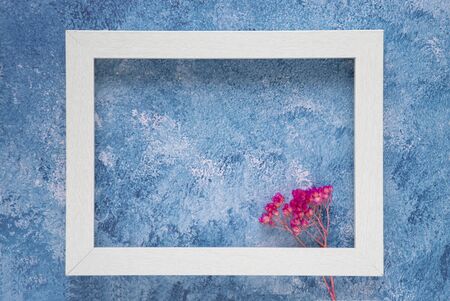 A white wooden frame mock up template on blue acrylic backgroundの写真素材