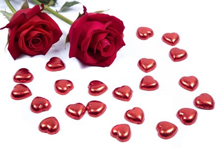 Closeup of beautiful red roses  on red candy hearts.  Valentine's,  anniversary, wedding concept.の写真素材