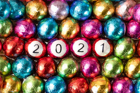 Closeup of multicolored chocolate candy balls with 2021 numbers.の写真素材