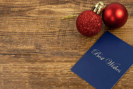Two red Christmas baubles and a blue car with gold Best Wishes letters.