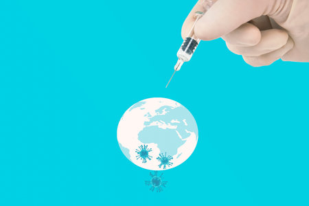 Covid-19 worldwide immunization concept with a hand of a healthcare person holding a glass syringe pointing to the Earth sphere illustration with 3D rendering vial particles.の写真素材