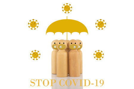 A group of wooden models with face masks and a large gold umbrella surrounded by 2d illustrations of viruses with a text banner reading STOP COVID-19.の写真素材