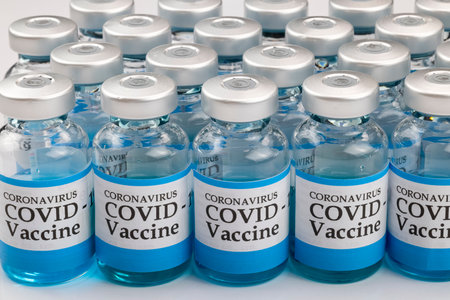 Glass vials labelled with COVID-19 text on white background. Covid-19 vaccine concept.
