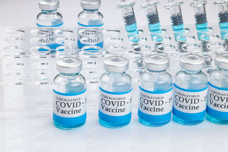 Glass vials labelled with COVID-19 text on white background. Covid-19 vaccine concept.