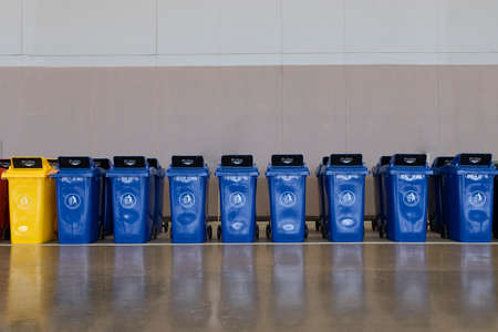 A row of large dark blue industrial plastic garbage containers.の写真素材