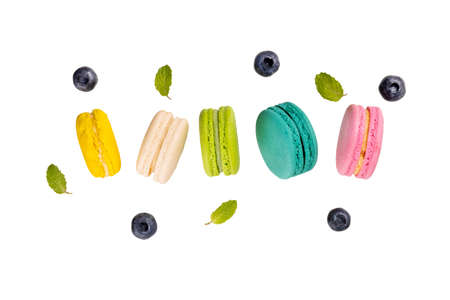 Colorful macaroons  levitating on white background with blueberries and mint leaves.