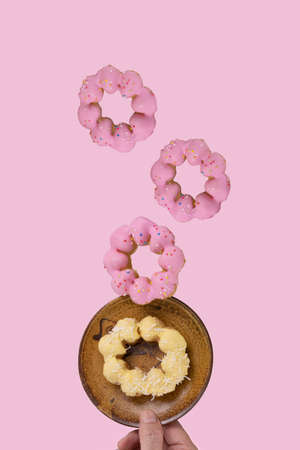 Glazed donuts leviating with soft pink color background. Levitation food concept.の写真素材