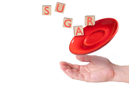 A hand holding out with a plate and levitating wooden letter blocks spelling sugar.