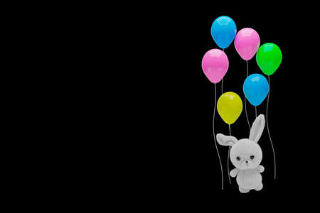 3d render illustration of a cute stuffed toy rabbit holding balloons on black background.の写真素材