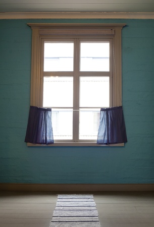 Old window with blue curtains in empty roomの写真素材
