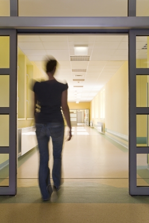 Young women entering a hospital corridorの写真素材