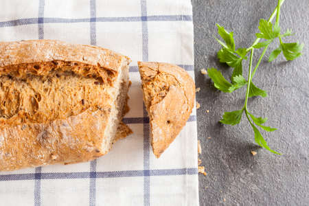 Tasty bread sliced on kitchen towel and parsleyの写真素材