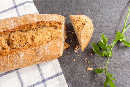 Tasty bread sliced on kitchen towel and parsleyの写真素材