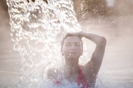 Happy young woman relaxing in thermal pool.の写真素材