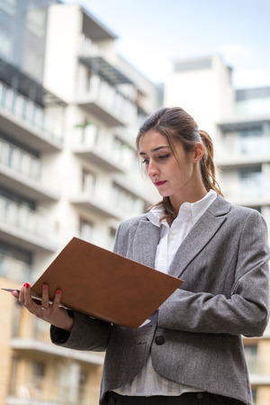 Businesswoman looking at some documents outside yhe officeの写真素材