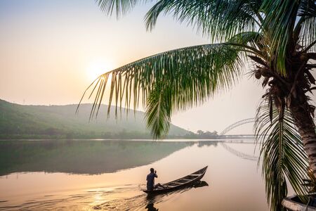 Paddling in traditional wooden canoe, Ghana, Africa