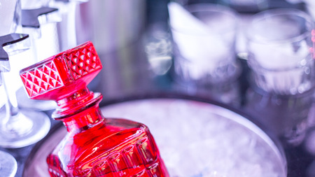 Bottle of strong alcohol and glasses in luxury limousine