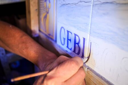 Painting traditional portuguese tiles called azulejos in Silves, Algarve, Portugalのeditorial素材
