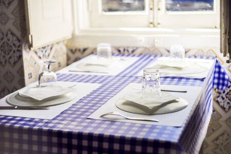 Table in Portuguese restaurant with traditional tiles ready for four peopleの写真素材