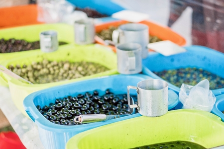 Variety of green and black seasoned olives for sell at open air marketの写真素材