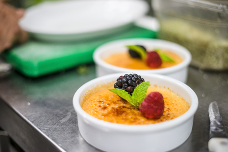 Freshly made Creme Brule with fresh fruits band mint leafの写真素材