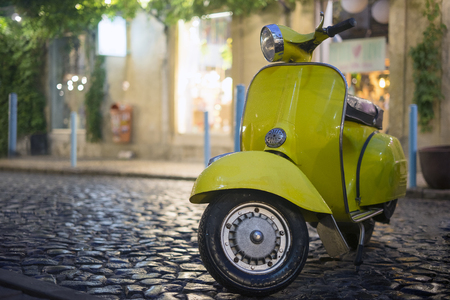 Classic Italian motorbike parked on cobblestone streetの写真素材