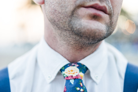 Close up of mouth and shoulders of stylish man wearing blue tie and suspendersの写真素材