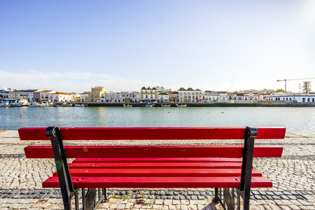 Red bench by Gilao river bank in charming Tavira, Algarve, Portugalの写真素材