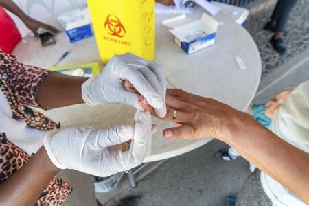 Nurse does a quick malaria test from blood on the South Africa and Mozambique border Lebombo Border Control, South Africaの写真素材
